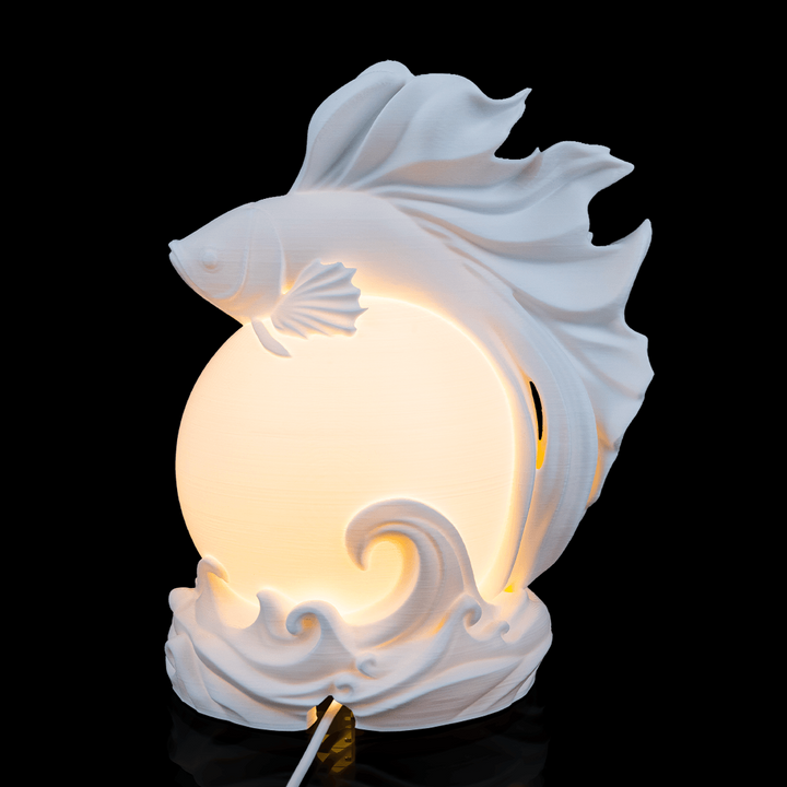 Decorative desk light with fish design on a black background