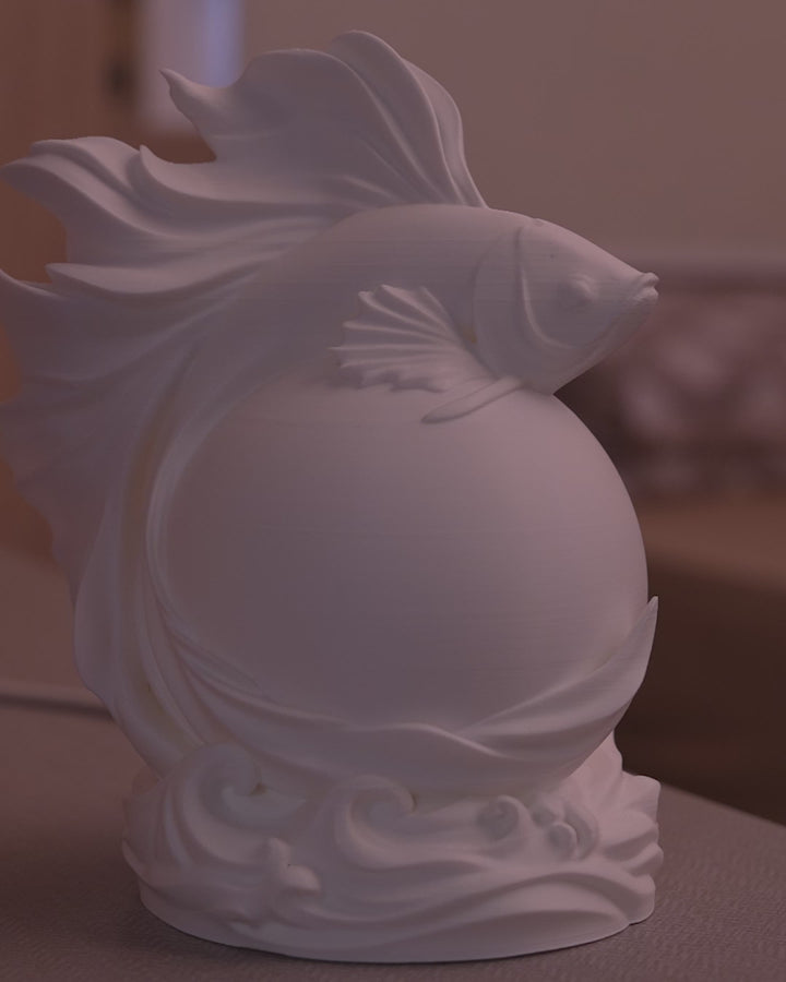  view of Betta Fish Sphere Desk Lamp showing flowing fin design circling the spherical globe and illuminating on desk